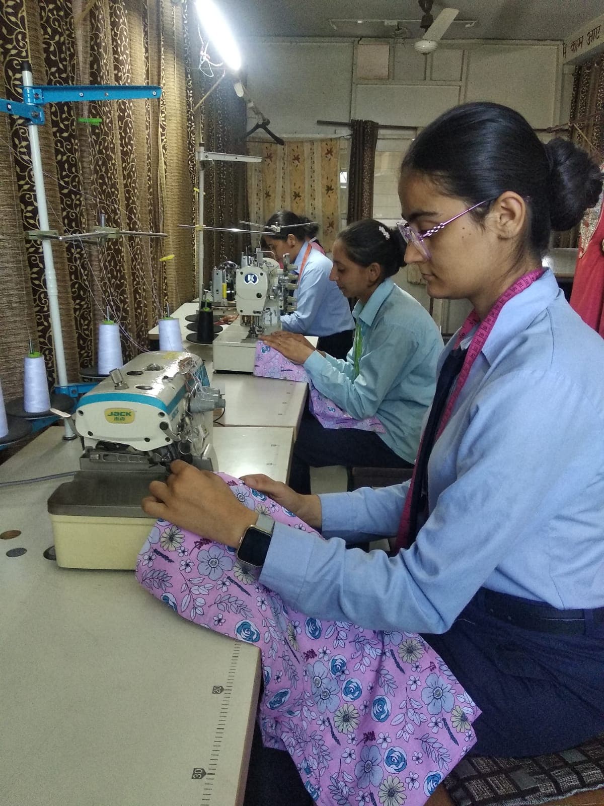 Fashion designing students at industrial sewing machines